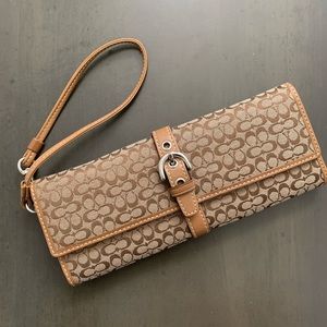 Coach wristlet with signature logo and leather inside.